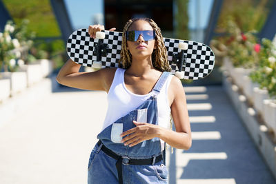 Portrait of young woman wearing sunglasses standing outdoors