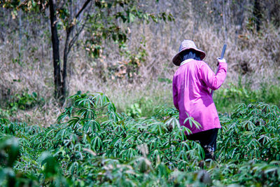 Rear view of woman walking on field