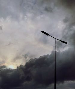 Low angle view of street light against cloudy sky