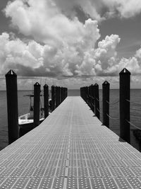 Wooden pier on sea against sky