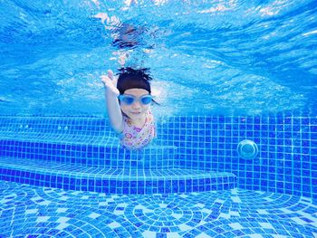 Girl swimming underwater in pool