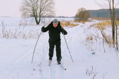 Full length of man skiing on snow field