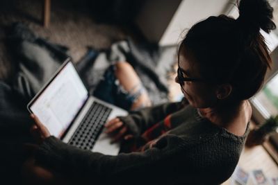 Woman using laptop while siting at home