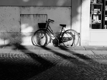 Bicycle parked against brick wall