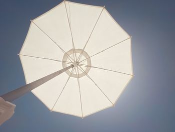 Low angle view of umbrella against clear blue sky