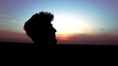Silhouette woman against sky during sunset