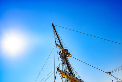 Low angle view of sailboat against blue sky