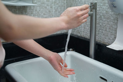 Midsection of man using mobile phone in bathroom