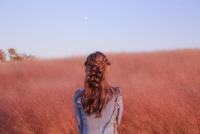 Rear view of woman standing on land against sky