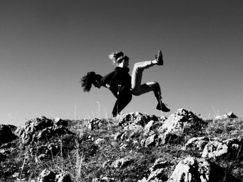 Low angle view of playful female friends against clear sky