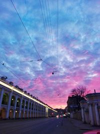 Cars on road against sky at sunset