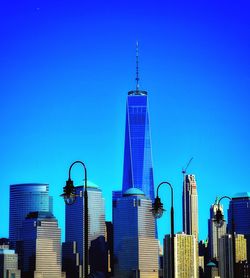 Skyscrapers in city against blue sky