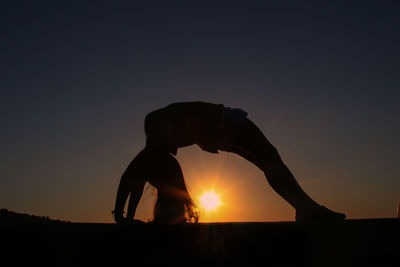 Silhouette man against orange sky during sunset