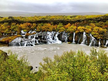 Scenic view of waterfall against sky