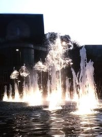 Close-up of water fountain against clear sky at night