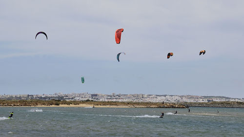 People kiteboarding at sea against sky