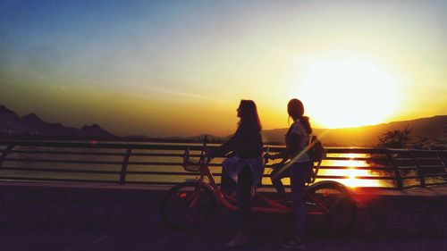 People riding bicycle at sunset