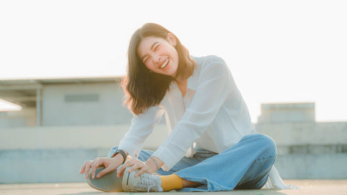 Smiling young woman sitting outdoors