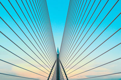 Low angle view of suspension bridge against blue sky