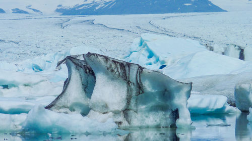 Snow covered landscape with sea in background