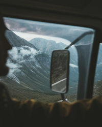 Man in vehicle against snowcapped mountains