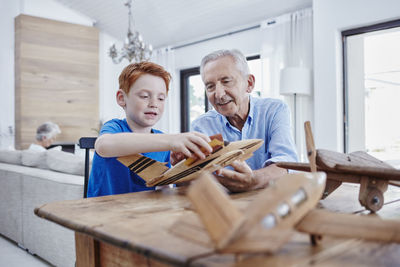 Grandfather and grandson building up model airplanes