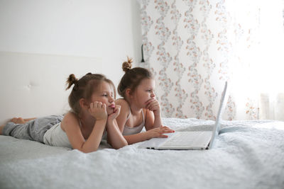 Children at home seriously working with laptop, concept of childhood and gadgets, life style, toning 