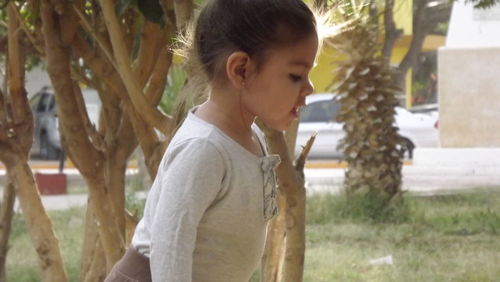 Portrait of girl standing against tree