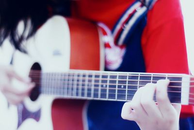 Midsection of woman playing guitar