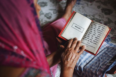 High angle view of woman reading book at home