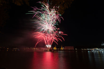 Firework display over river at night