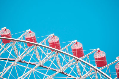 Low angle view of ferris wheel against clear blue sky