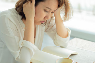 Woman looking at blank book in home