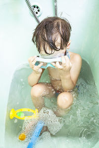 Midsection of shirtless boy in bathroom at home