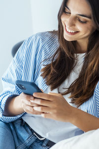 Portrait of young woman using mobile phone