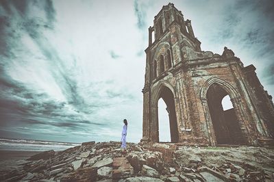 Low angle view of old building against cloudy sky