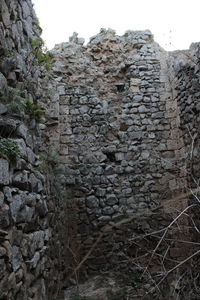 Low angle view of stone wall against sky