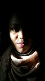 Close-up portrait of young woman in darkroom