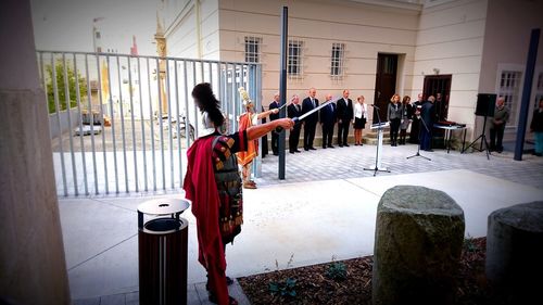 Rear view of people standing against built structure