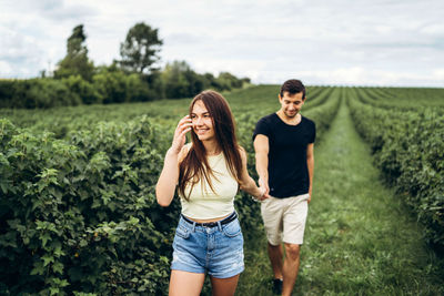 Full length of smiling young woman standing on land