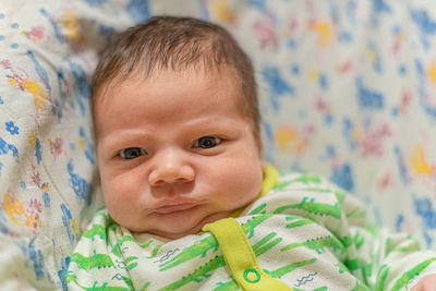 Portrait of infant baby lying in his bed