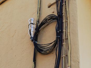 Low angle view of electric lamp hanging on wall