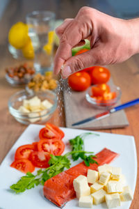 Cropped hand of person preparing food on table