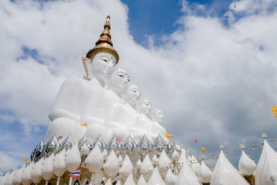 Low angle view of statues on building against sky