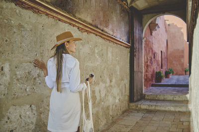 Full length of woman standing against building