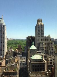 Buildings in city against blue sky