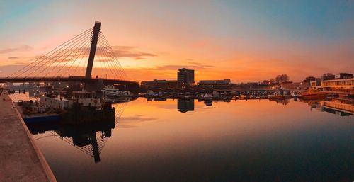 Sailboats in city at sunset