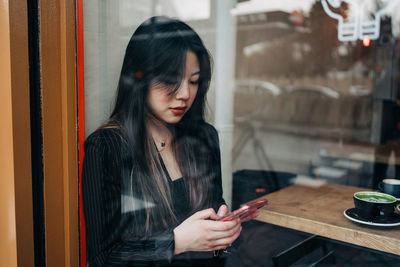 Young woman looking through mobile phone