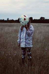 Full length of girl standing on field against sky