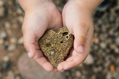 Photo of a heart-shaped stone in children's hands